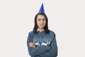 Woman wearing Christmas jumper and party hat